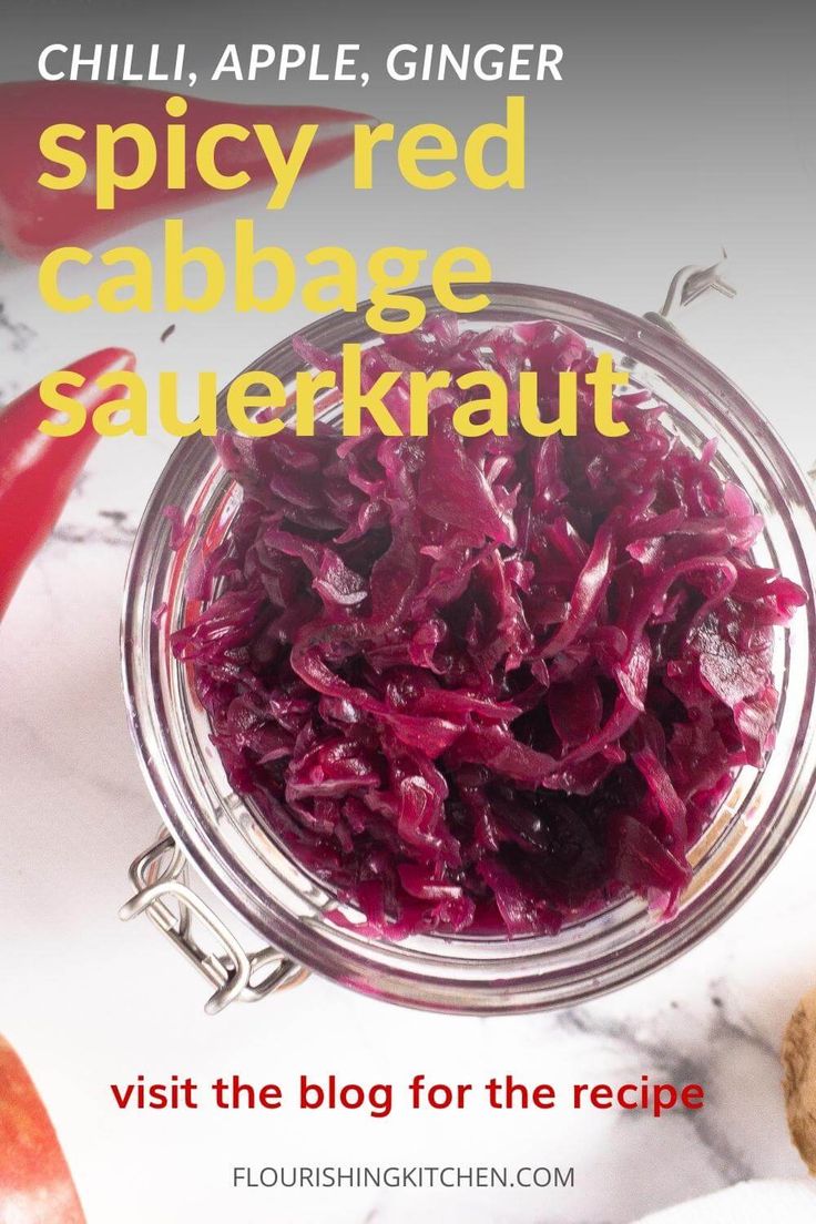 red cabbage sauerkraut in a glass jar on a marble counter top with the title, spicyred cabbage sauerkraut visit the blog for the recipe