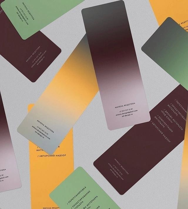 several business cards are laying on top of each other, with different colors and shapes