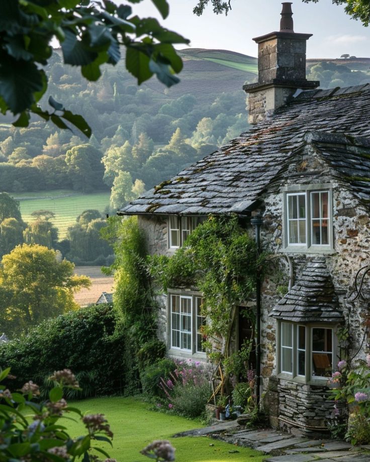 an old stone house surrounded by greenery in the countryside