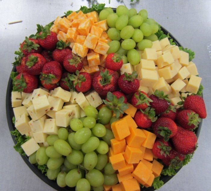 a platter filled with fruit and cheese