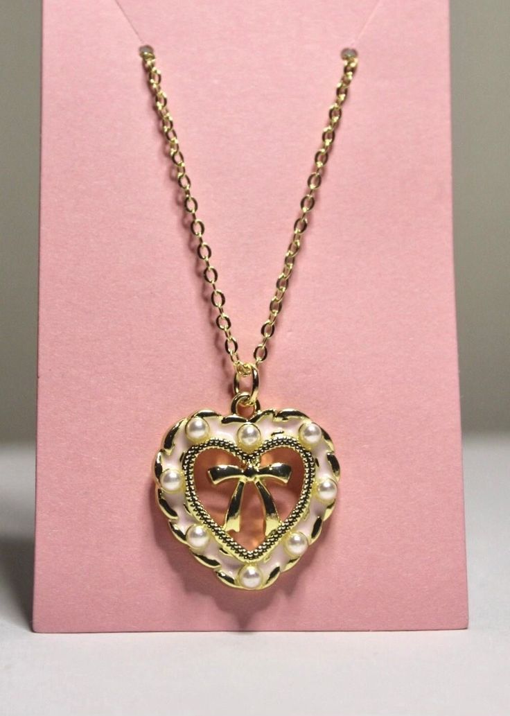 pink heart bow necklace  cute & dainty coquette style necklace  14k gold plated necklace 18, 20, & 24 inches  pendant is approximately 1inchx.75inch by purchasing from Kristen's Kollection's the customer agrees that the use of the jewelry is entirely at the customer's own risk. Warning: jewelry may be a choking hazard, please keep away from children. Final sale. Heart Coquette Necklace, Heart Necklace Princess, Luxury Romantic Heart-shaped Necklace, Cheap Rose Gold Heart Charm Necklaces, Affordable Romantic Heart Necklace For Valentine's Day, Affordable Heart Necklace For Valentine's Day, Cheap Heart Charm Necklace For Romantic Gift, Luxury Heart-shaped Romantic Necklace, Luxury Heirloom Heart Pendant Necklace