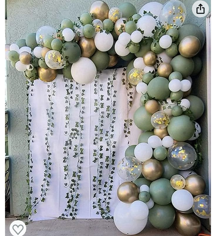 an arch made out of balloons and greenery