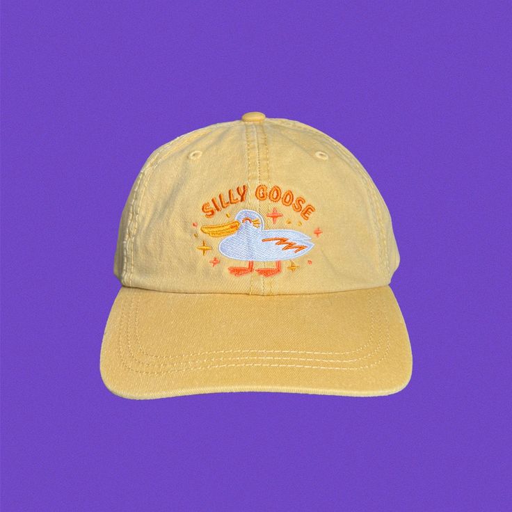 If you're a silly goose and you know it, this hat is for you! Embroidered directly onto a super comfy wheat colored dad hat. Hat specs: 100% cotton pigment dyed twill Unstructured, six-panel, low profile Self-fabric sweatband and six sewn eyelets Self-fabric strap with brass snap buckle and sewn grommet I understand that it's hard to know if a hat fits until you try it on, I accept returns on all hat purchases, buyer pays for return shipping. Only available for purchases in the US. Retro Cotton Cap, Fun Cotton Snapback Trucker Hat, Retro Cotton Trucker Hat With Curved Brim, Fun Adjustable Cotton Dad Hat, Retro Cotton Dad Hat With Curved Bill, Yellow Cotton Trucker Hat With Curved Brim, Cute Cotton Baseball Cap With Curved Brim, Retro Cotton Dad Hat With Embroidered Logo, Novelty Cotton Baseball Cap One Size Fits Most