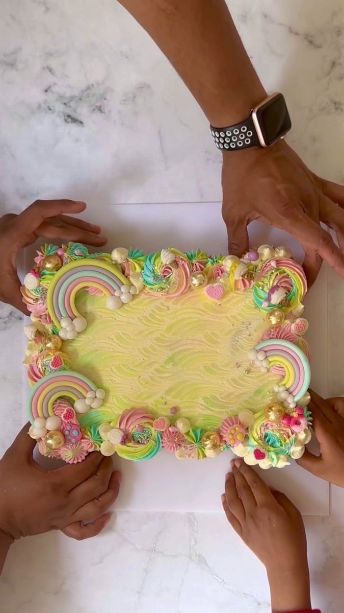 several people are holding a cake decorated with candy