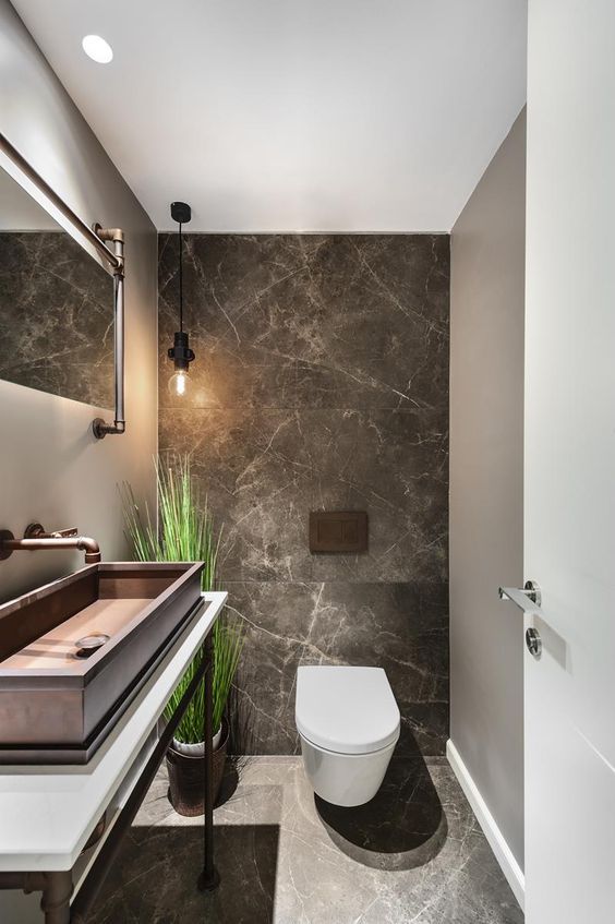 a bathroom with a toilet, sink and large mirror in it's center area