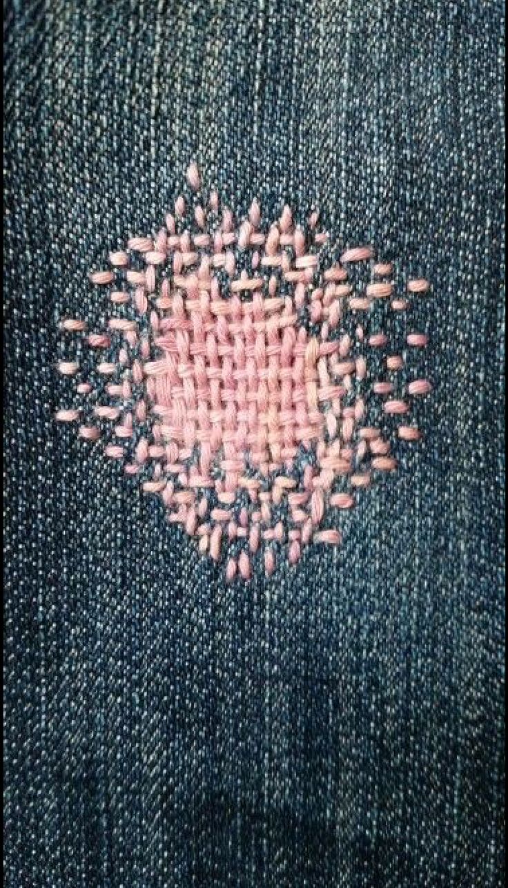 the back side of a pair of blue jeans with pink stitching on it and an embroidered heart