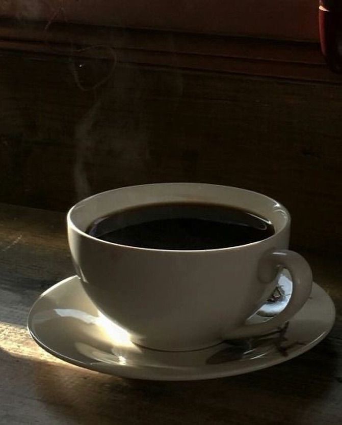 a cup of coffee sitting on top of a saucer with steam coming out of it