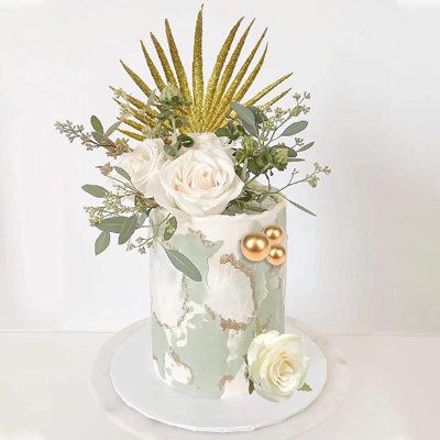 a white cake with flowers and greenery on top