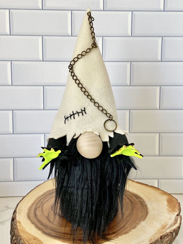 a white and black gnome hat sitting on top of a tree stump