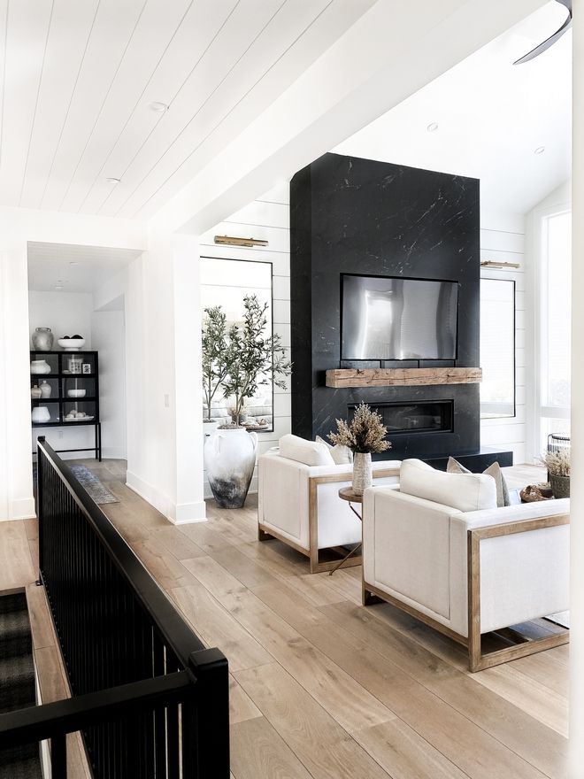 a living room filled with white furniture and a flat screen tv mounted to the wall