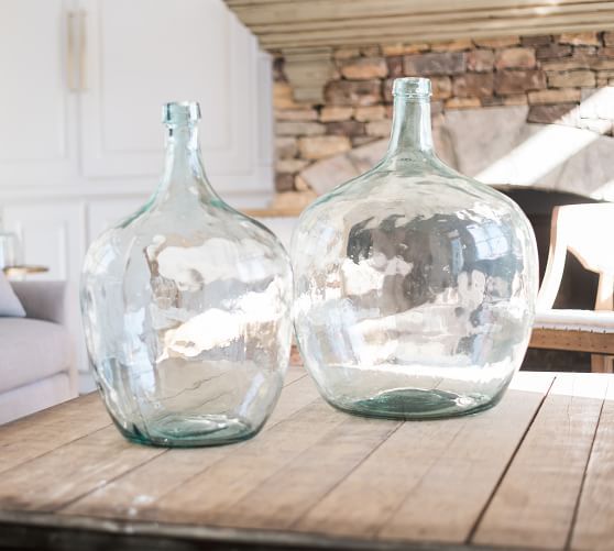 two glass vases sitting on top of a wooden table