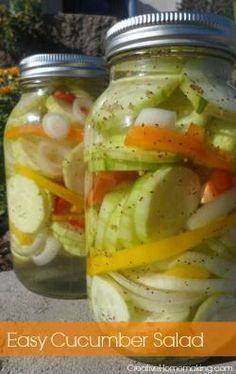 two mason jars filled with pickled vegetables and lemons, sitting on the ground