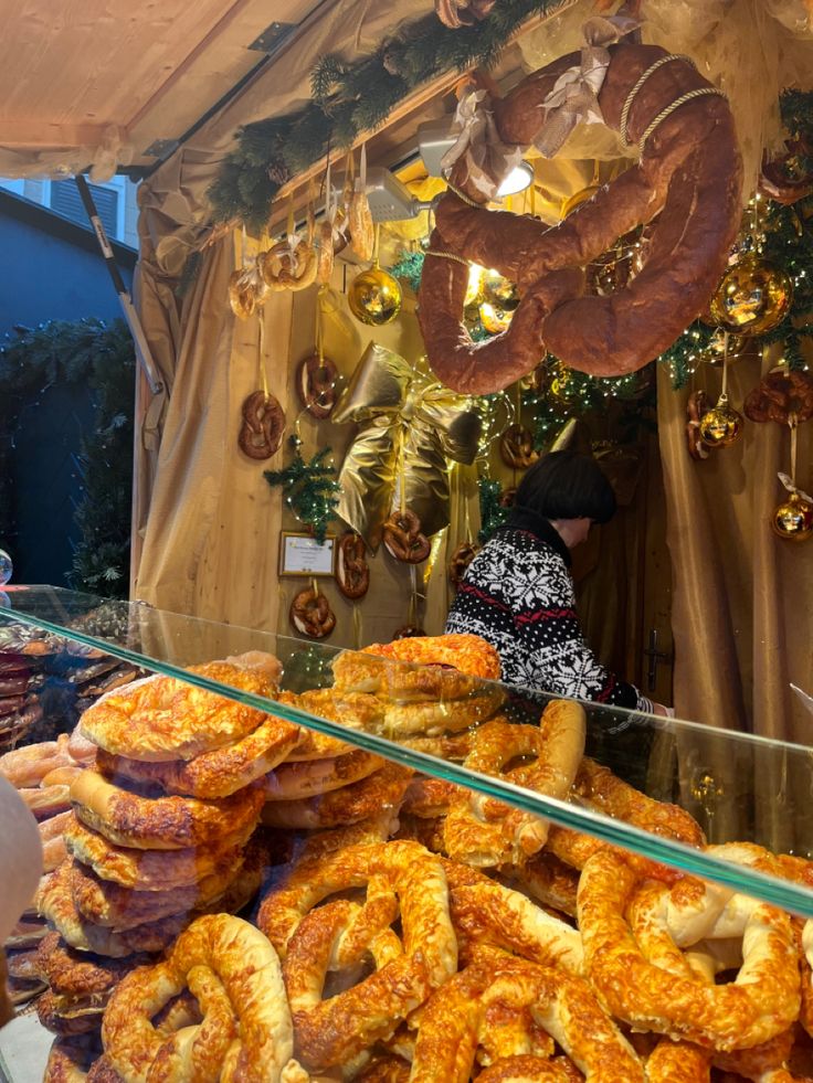 there are many different types of breads on display in the store window, including pretzels and doughnuts