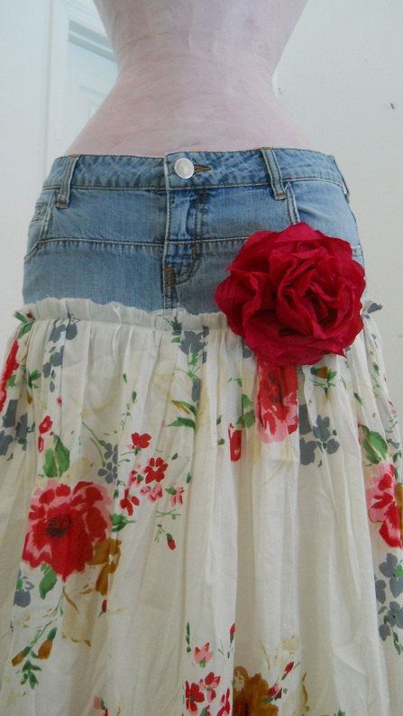 a woman's skirt with a flower on the bottom and an old pair of jeans underneath it