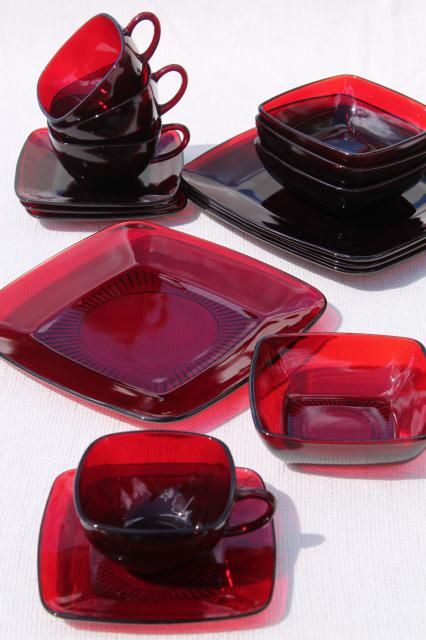 red glass dishes and cups on a white tablecloth