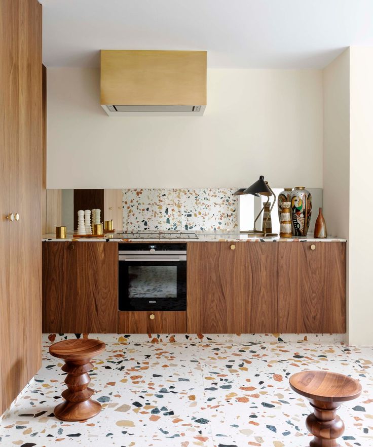 a kitchen with an oven, counter and stools on the floor in front of it