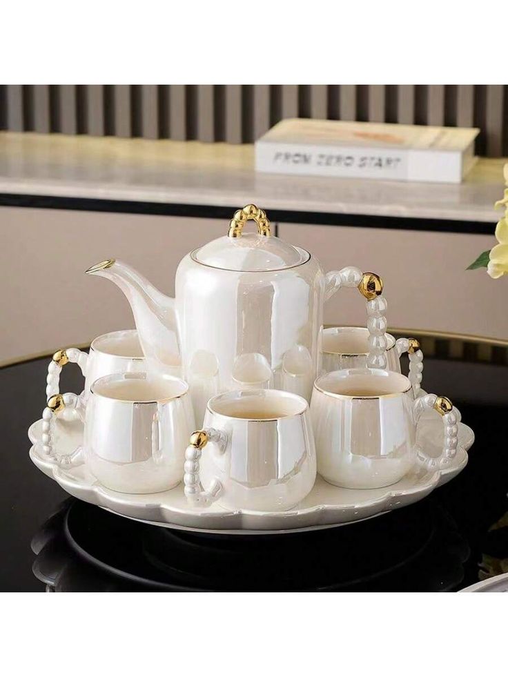 a white tea set sitting on top of a black table