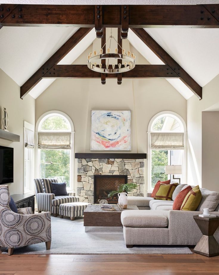 a living room filled with furniture and a fire place in the middle of an open floor plan