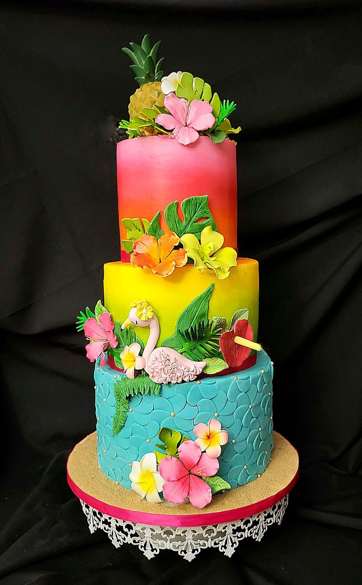 a multi layer cake with flowers and leaves on top