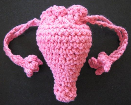 a crocheted pink hat with two bows