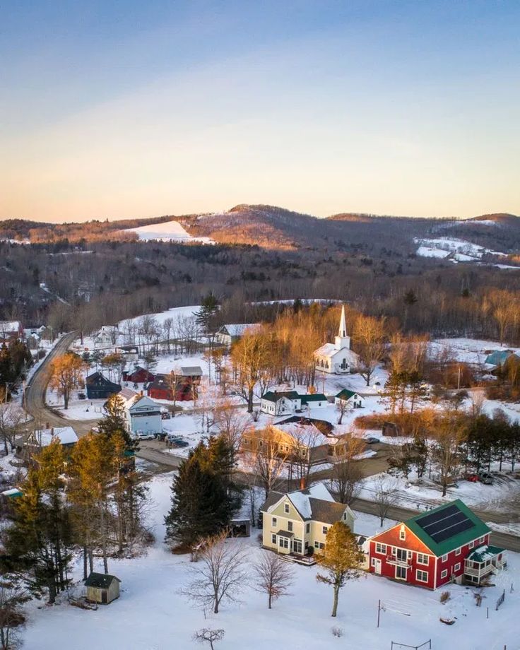 an aerial view of a small town in the winter with lots of snow on the ground