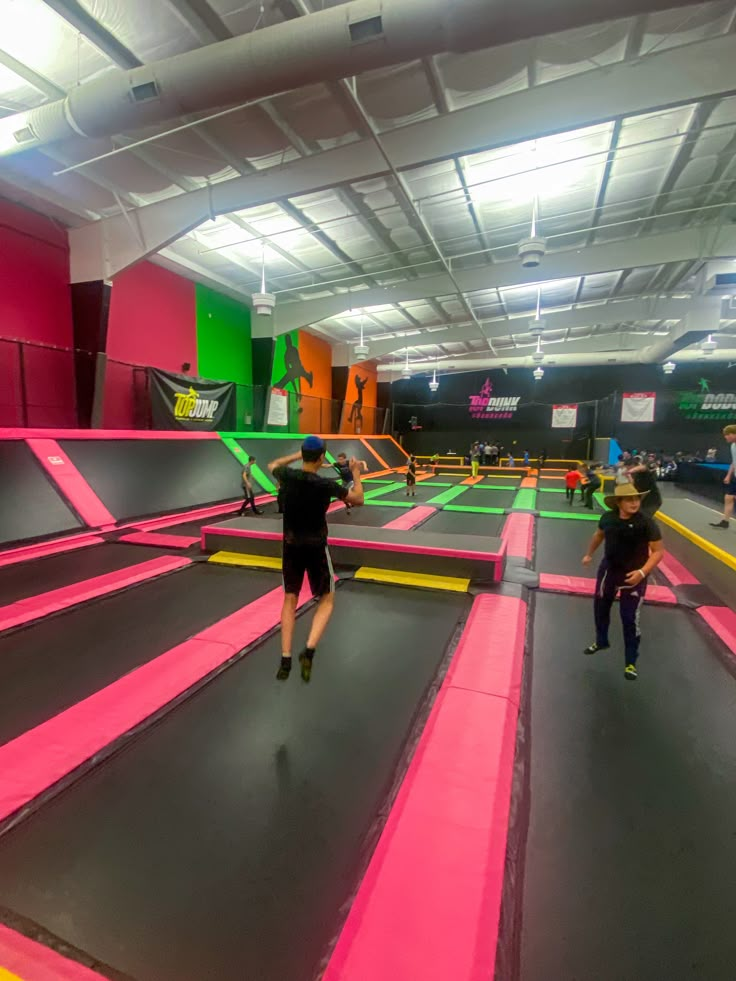 people are playing on an indoor trampoline course in the gym with neon colors