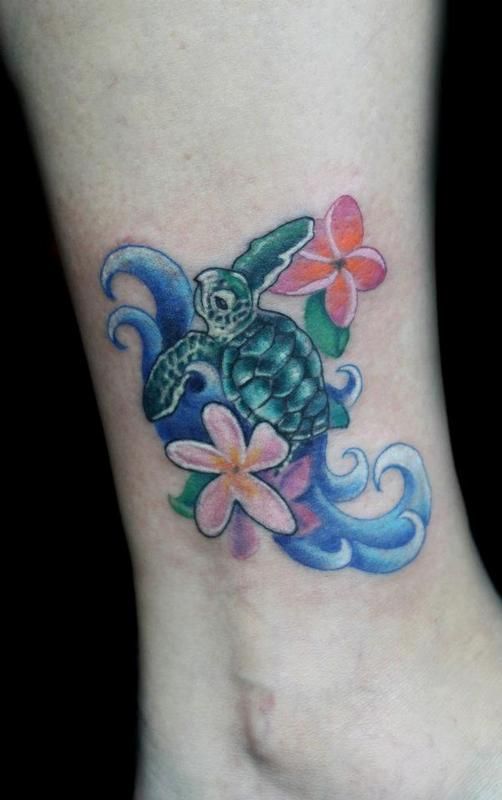 a tattoo on the foot of a woman with flowers and a sea turtle in it