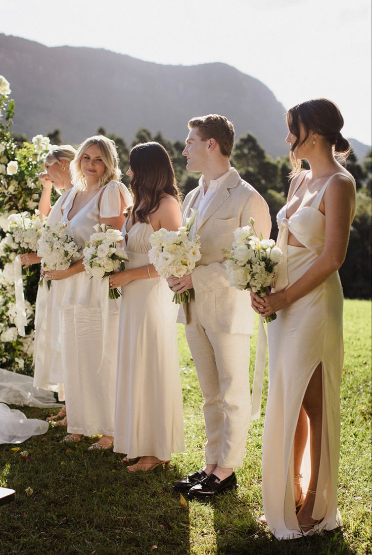 a group of people standing next to each other on top of a lush green field