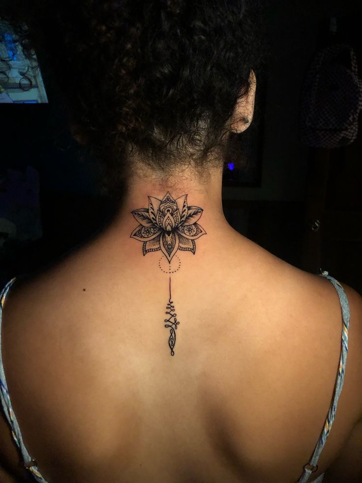 the back of a woman's neck with a tattoo on it