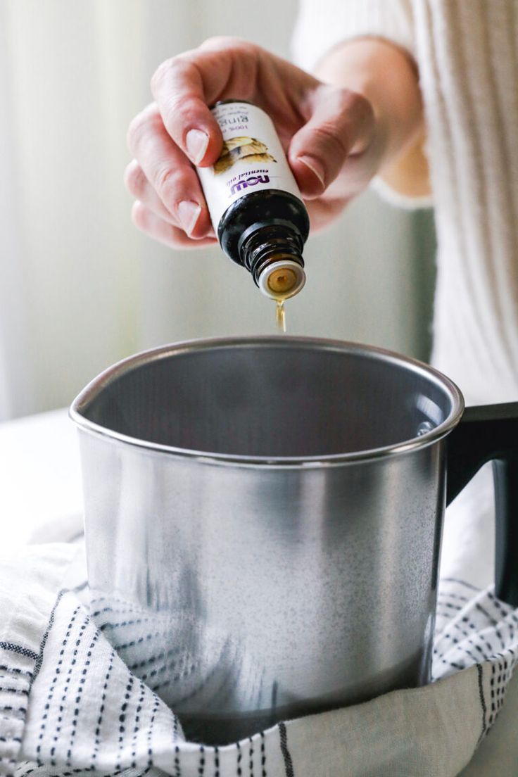 a person pouring oil into a saucepan