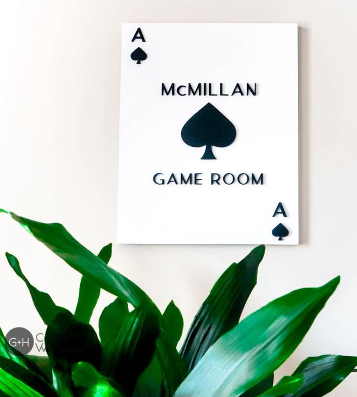 there is a card game room sign on the wall next to a potted plant