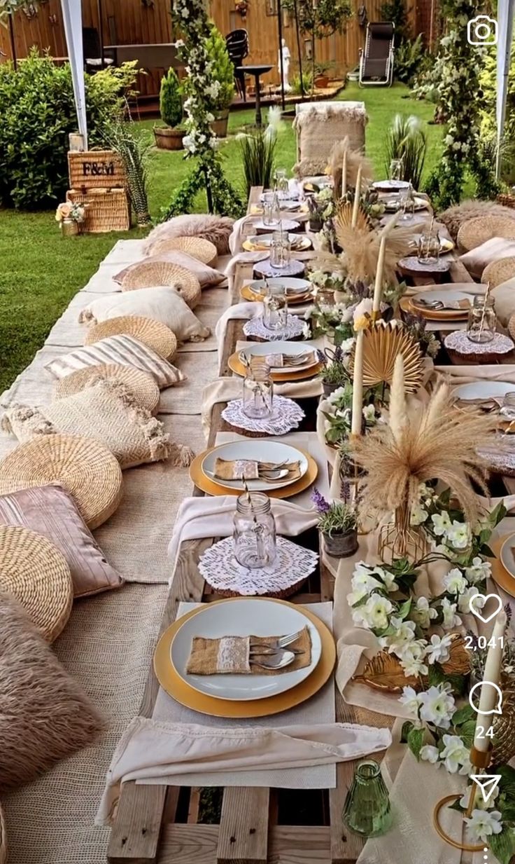 a long table is set with plates and place settings for an outdoor dinner or party