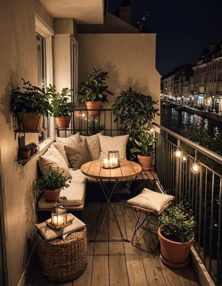 the balcony is lit up with candles and potted plants