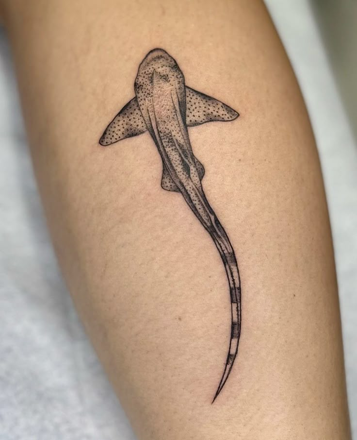 a tattoo on the leg of a person with a long tail and an animal's head