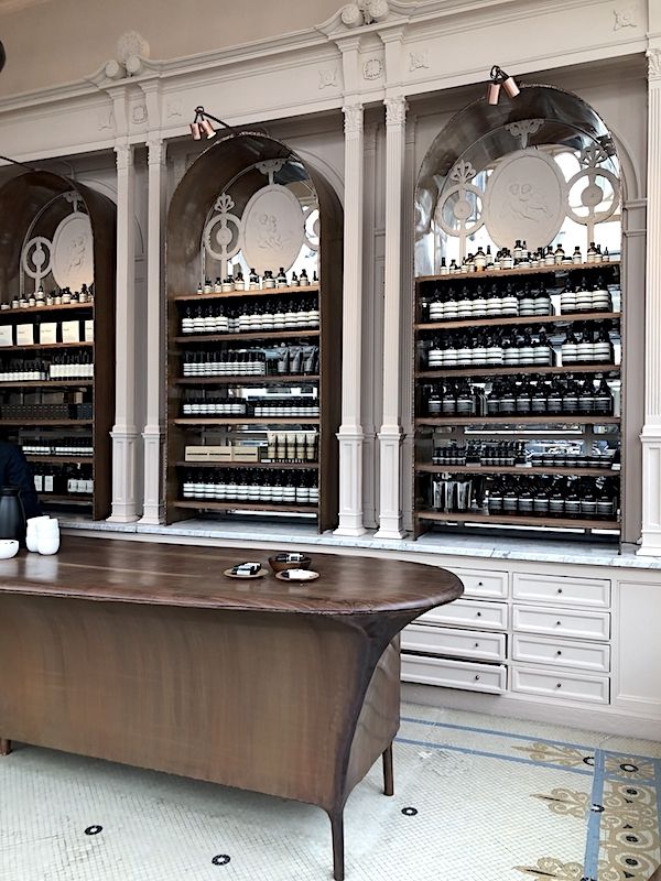 a large wooden desk sitting in front of shelves filled with bottles