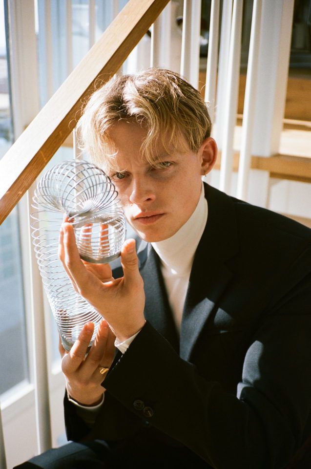 a man in a suit and tie holding a fan