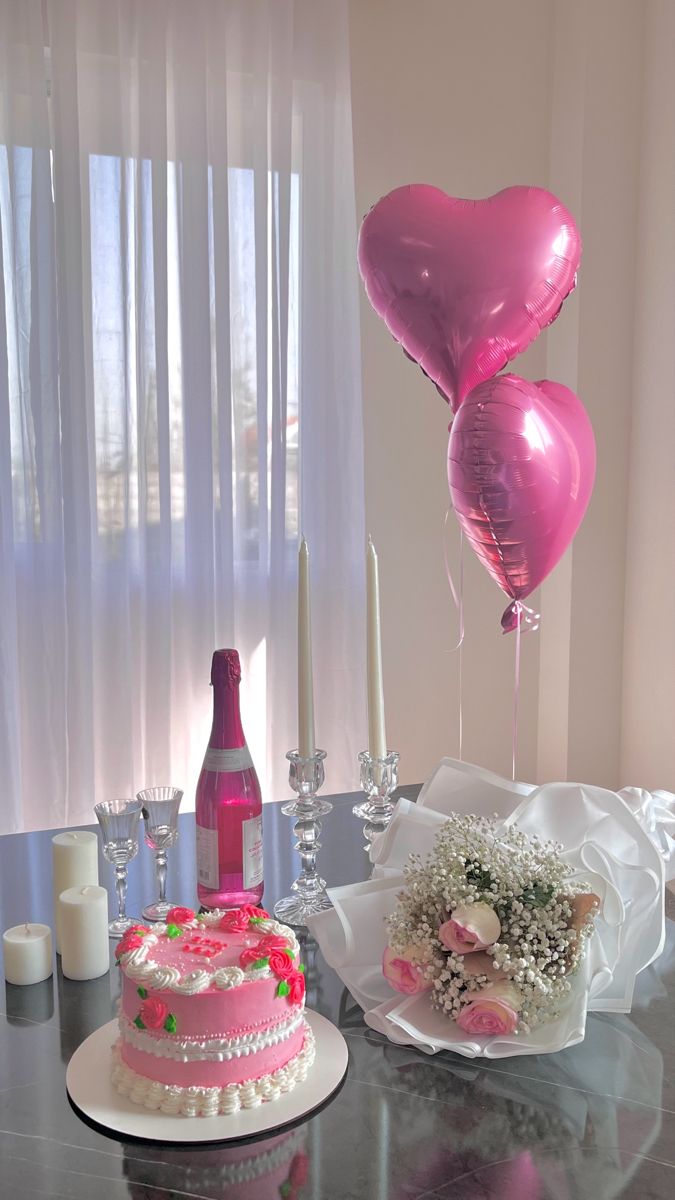 a table topped with a cake and balloons