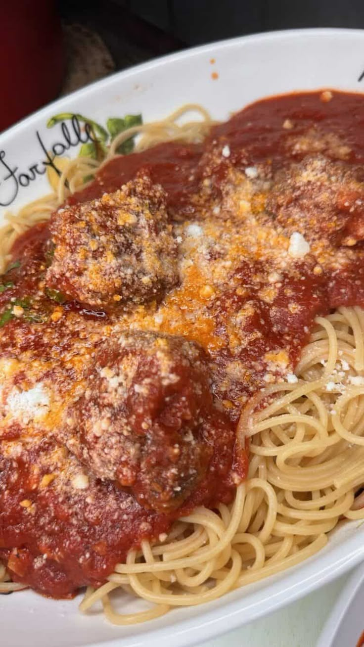 a white plate topped with spaghetti and sauce