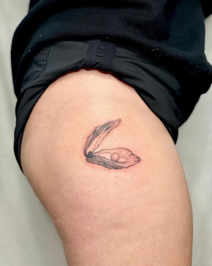 a woman's thigh with a bird tattoo on it