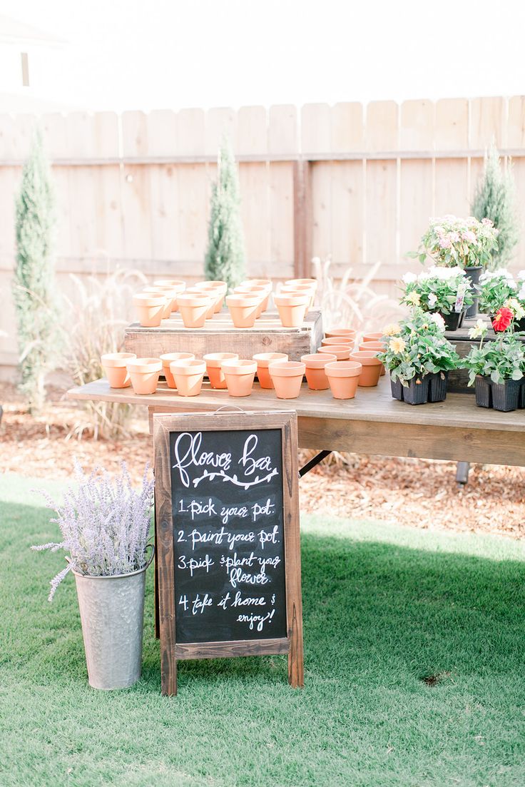 a table with potted plants on it and a chalkboard sign next to it