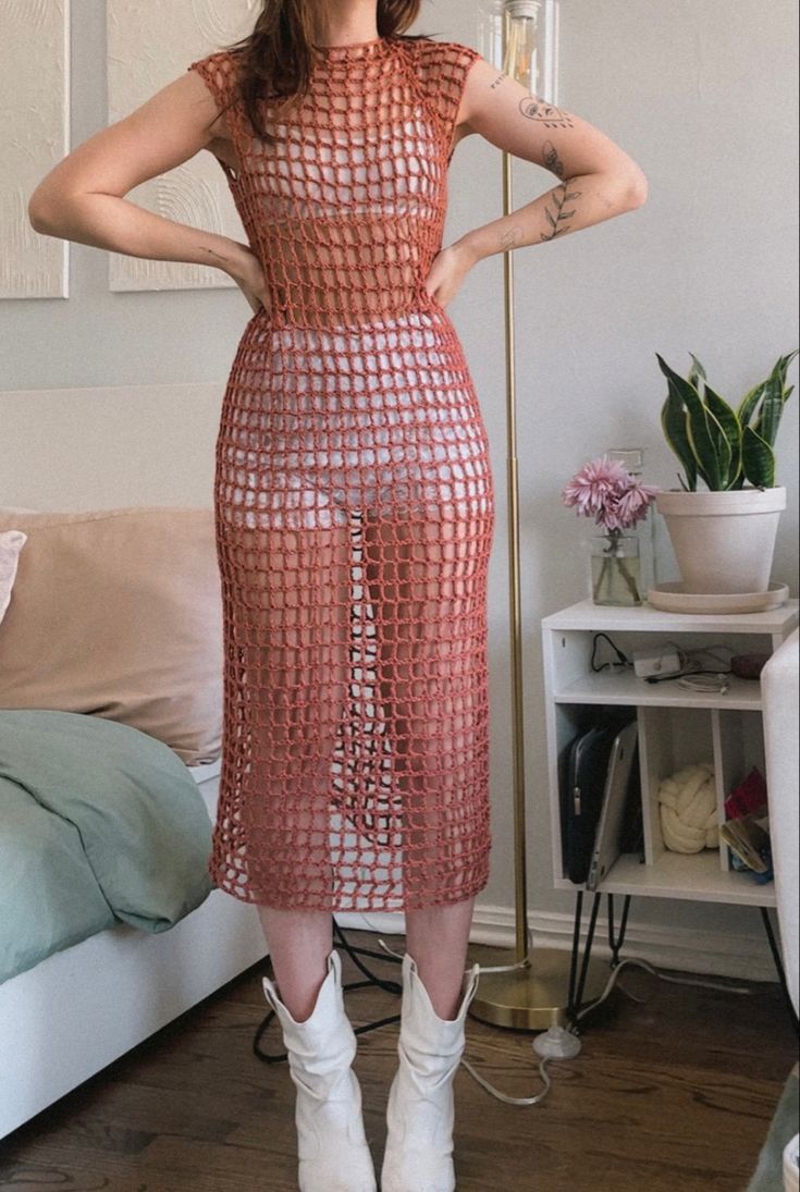 a woman standing in front of a mirror with her hands on her hips and wearing white boots