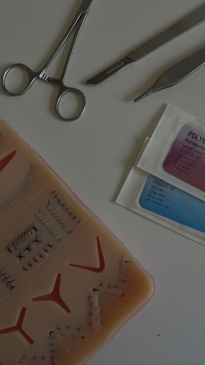 some scissors and other items are laying on a white surface with a plastic package next to it