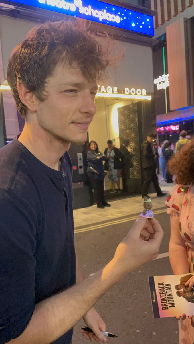 a man standing on the street holding something in his hand