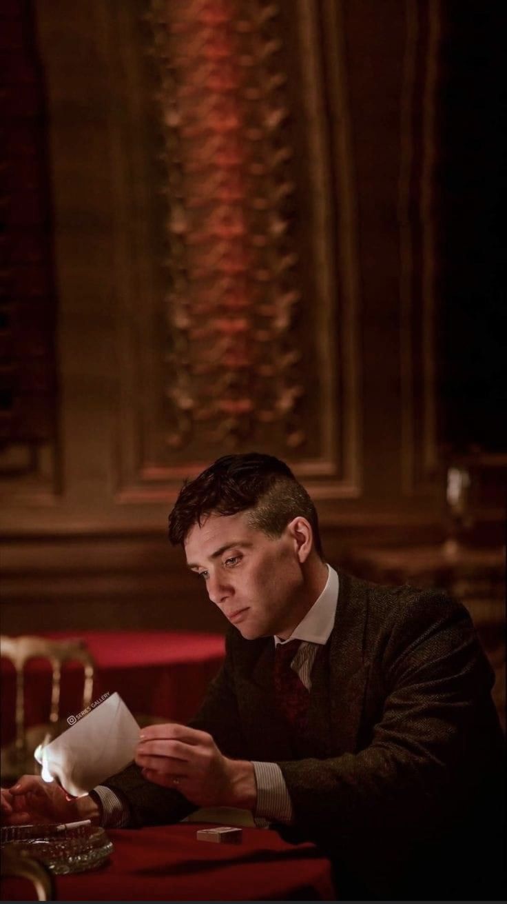 a man sitting at a table with a paper in his hand