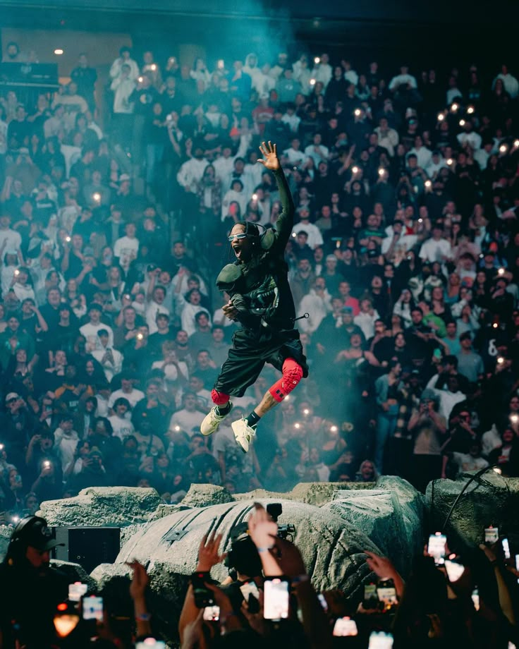 a man is jumping in the air at a concert