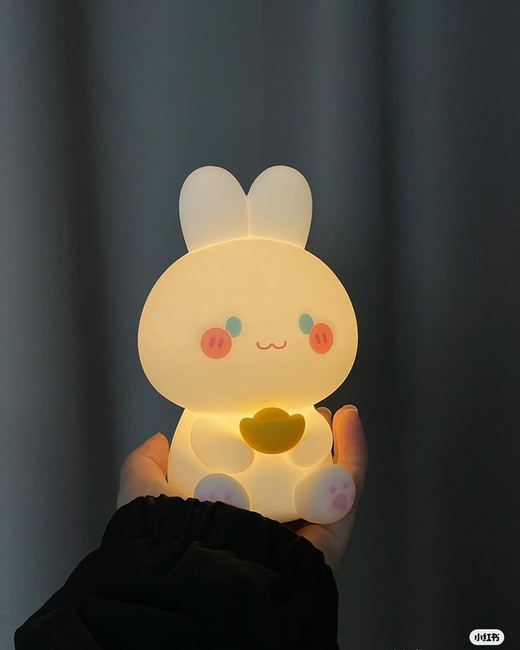 a person holding up a small light in their hand, with an animal on it's chest