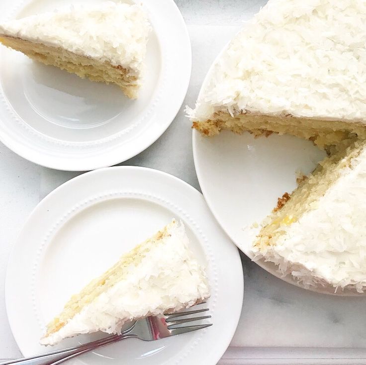 two white plates with slices of cake on them and one slice missing from the cake