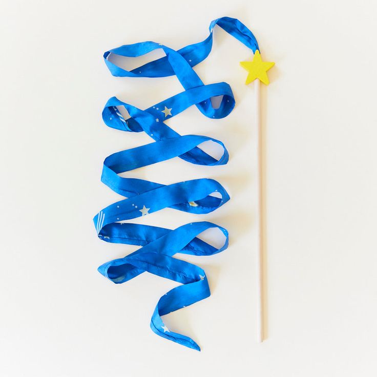 blue streamers and a wand on a white surface with a star in the middle