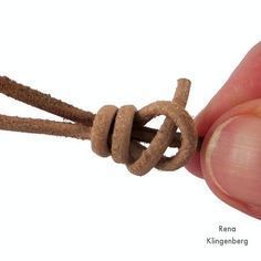 a hand holding a piece of rope that is knoted together