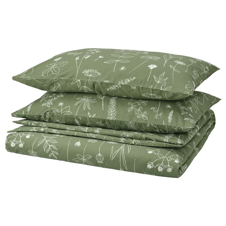 three pillows stacked on top of each other with green and white floral designs in them